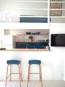 a kitchen with two blue bar stools in front of a counter at Le Bigorneau , beach at 20m and free private carpark in Saint Malo