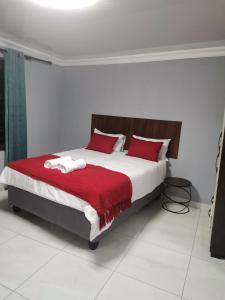 a bedroom with a large bed with red pillows at Unogwaja Rest in Marloth Park