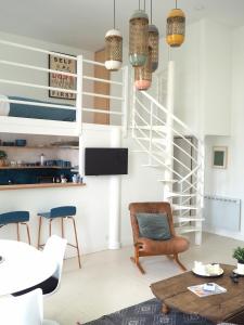 a living room with a staircase and a table and chairs at Le Bigorneau , beach at 20m and free private carpark in Saint Malo