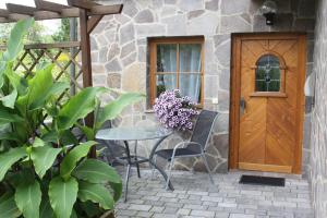 een patio met een tafel en stoelen en een houten deur bij Apartment Mona in Wetzlar