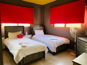 two beds in a room with red windows at Laura’s Modern Villa in Madaba