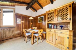 een eetkamer met een houten tafel en stoelen bij Chalet Marianna in Meltina