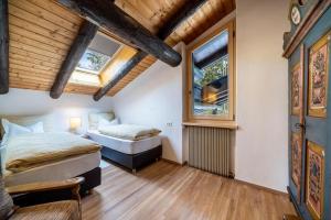 twee bedden in een kamer met twee ramen bij Chalet Marianna in Meltina