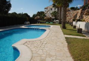 una piscina con una pasarela de piedra junto a una casa en Nice apartment in a wonderful area, en Villacosta