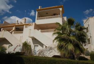 un edificio con una palmera delante en Nice apartment in a wonderful area, en Villacosta