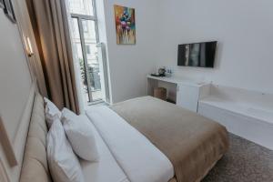 um quarto de hotel com uma cama e uma televisão em Callisto Hotel em Baku