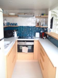 a kitchen with wooden cabinets and blue tiles at Le Bigorneau , beach at 20m and free private carpark in Saint Malo