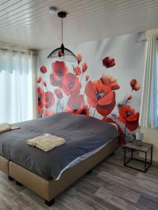 - une chambre avec un lit orné de fleurs rouges sur le mur dans l'établissement Mary's Poppies - Bed & Breakfast, à Blandain