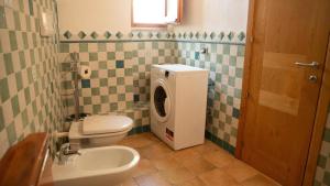 Un baño con inodoro y lavadora. en Casa Tipica vista mozzafiato, en Posada 68 fotos más