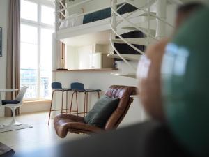 a person sitting in a chair in a living room at Le Bigorneau , beach at 20m and free private carpark in Saint Malo