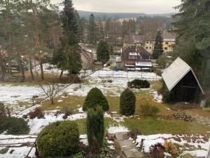 Svratka的住宿－apartman Luník，一座有树木和房子的雪地庭院