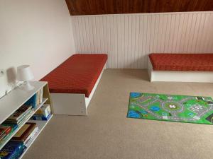 a small room with two beds and a rug at apartman Luník in Svratka