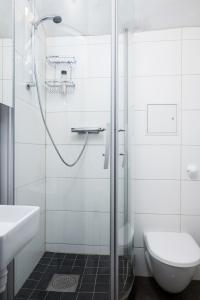 a bathroom with a shower and a toilet and a sink at Hotell Skeppsbron in Stockholm