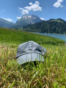 Un cappello seduto sull'erba in un campo di Fischers Lodge a Innerthal