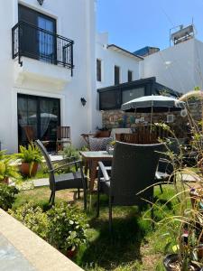 een patio met stoelen, een tafel en een parasol bij Arden's House in Bodrum City