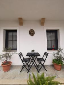 una mesa y sillas frente a una pared blanca en Arden's House, en Bodrum City