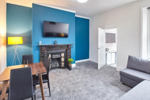 un soggiorno con pareti blu e camino di Host & Stay - 58 Dilston Road a Newcastle upon Tyne