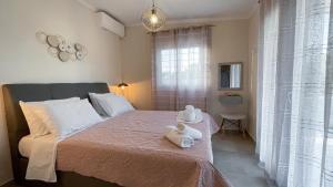 a bedroom with a bed with two stuffed animals on it at Averto House Lefkada in Lefkada Town