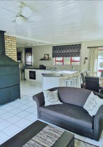 a living room with a couch and a kitchen at Bushmans River Holliday House Retreat in Bushmans River Village