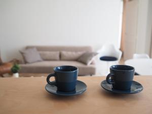 two black coffee cups sitting on top of a table at Le Bigorneau , beach at 20m and free private carpark in Saint Malo