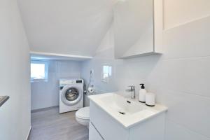 a white bathroom with a washing machine and a sink at Villa MAAS in Loborika for 10 persons in Loborika