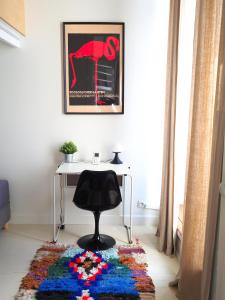 a desk and a chair in a room with a rug at Le Bigorneau , beach at 20m and free private carpark in Saint Malo