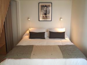 a bedroom with a large bed with two pillows at Le Bigorneau , beach at 20m and free private carpark in Saint Malo