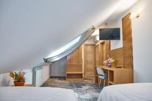 a room with two beds and a desk and a tv at Motel Eden in Rîmnicu Sărat