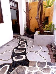 a walkway in front of a house with a tree at Dihini Villa in Unawatuna