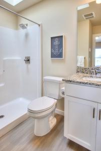 a white bathroom with a toilet and a sink at Crabby Daddy The Blue Mermaid in Ocean Shores +34 photos