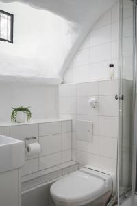 La salle de bains blanche est pourvue d'une douche et de toilettes. dans l'établissement Hotell Skeppsbron, à Stockholm