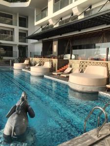 une statue d'un dauphin dans une piscine dans l'établissement Toà Nhà Apec Mandala Wyndham Phú Yên, à Tuy Hoa