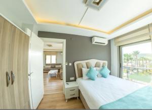 1 dormitorio con cama blanca y almohadas azules en Sigacik Marina Apart Hotel en Siğacık