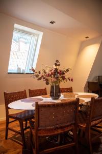 Luxury apartment in Bergen's Gastronomic district في بيرغِن: طاولة غرفة الطعام مع إناء من الزهور عليها