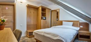um quarto com uma cama, uma secretária e uma mesa em Hotel Eden em Rimnicu Sarat