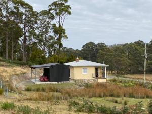 una piccola casa gialla e nera in un campo di Aruma Cottage Bruny Island ad Alonnah Altre 22 foto
