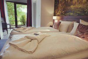 two beds in a hotel room with towels on them at Hotel Mein Bergblick in Hahnenklee-Bockswiese