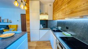 a kitchen with white cabinets and a counter top at Appartamento Treize - Affitti Brevi Italia in Bardonecchia
