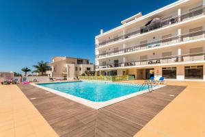 a swimming pool in front of a building at Vandalou By ALzira in Albufeira