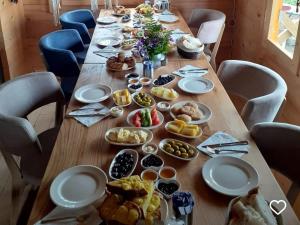 a long wooden table with plates of food on it at POKUT HELUN in Rize