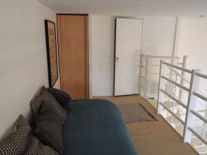 a living room with a blue couch and a staircase at Le Bigorneau , beach at 20m and free private carpark in Saint Malo