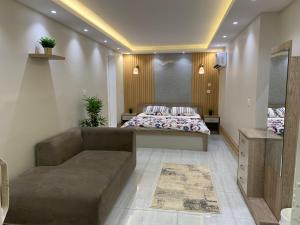 Habitación con 2 camas y sofá. en شالية فاخر بمسبح خاص بمكة المكرمة en Makkah