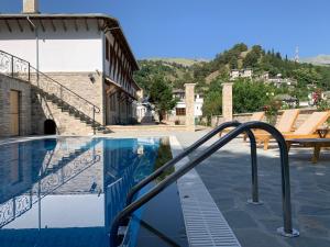 a swimming pool with a stairway leading to a building at Rose Garden Hotel in Gjirokastër