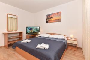 a bedroom with a bed with two towels on it at Apartments Vjeko in Makarska
