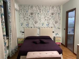 アルバにあるLa Maison du Soleil Appartamento Alba Pompeiaのベッドルーム(紫の毛布を使用した大型ベッド1台付)