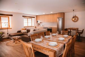 a kitchen and living room with a table and chairs at El Riveru - Astur Casas Rurales in Balmori