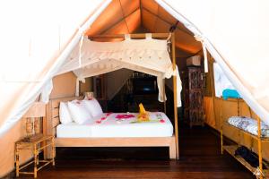 a bedroom with a bed in a tent at La Cocoteraie Ecolodge - Luxury Glamping Tents in Gili Trawangan