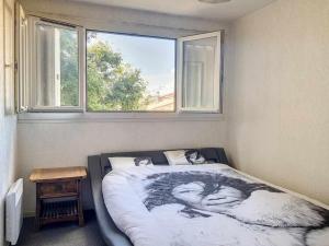 a bed in a bedroom with a large window at Plein centre ville Appartement in Salon-de-Provence