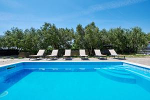 een zwembad met ligstoelen bij Villa Lilly in Kaštel Novi
