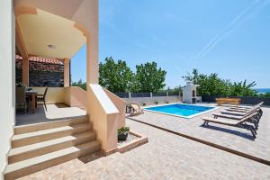 een huis met een zwembad en een patio bij Villa Lilly in Kaštel Novi